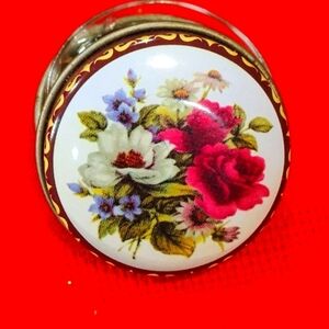 Vintage round metal pill box with floral print.